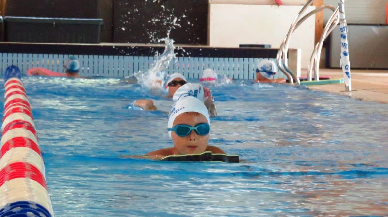 Copii veseli inotand in grup la piscina Obswim